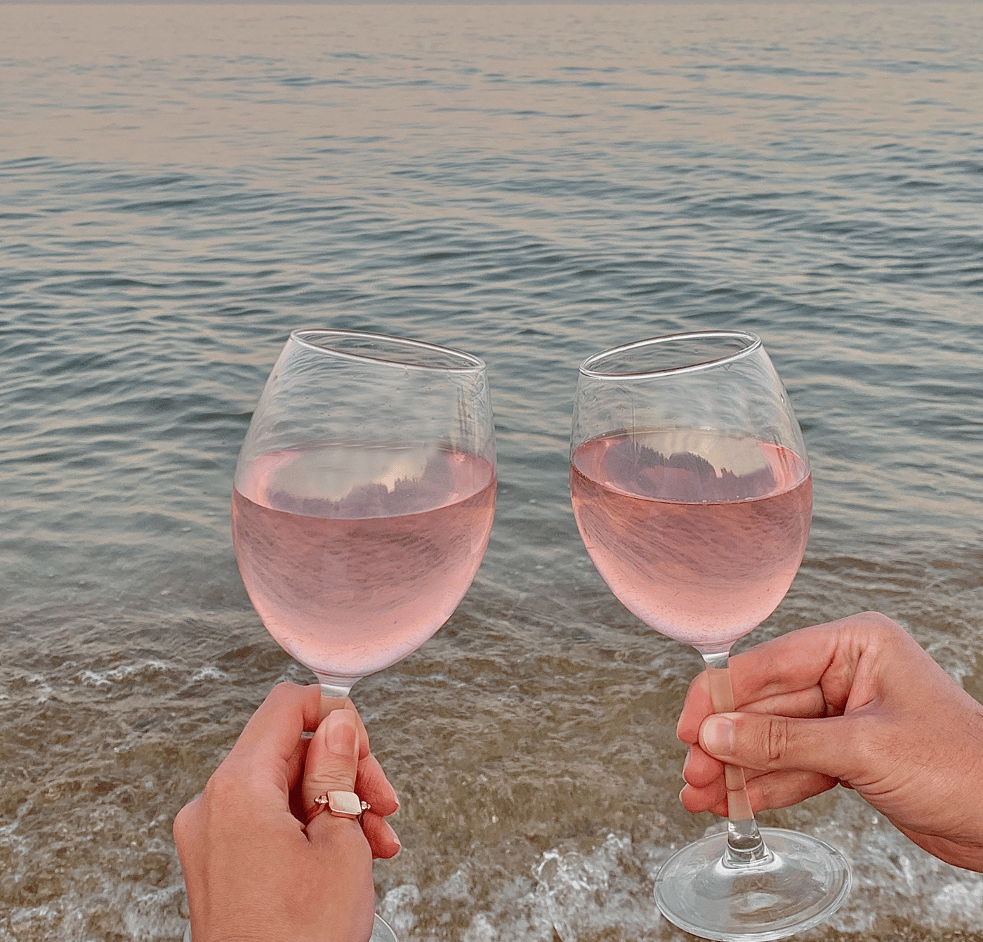 Two glasses of wine with the sea in the background.