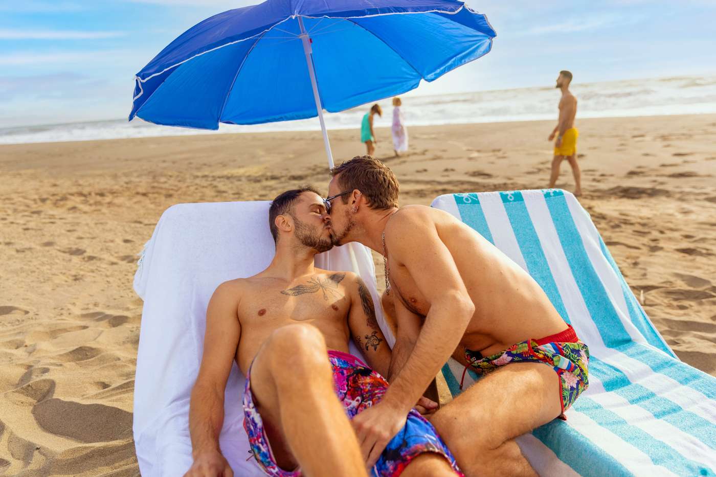 Couple kissing on sun loungers on the beach