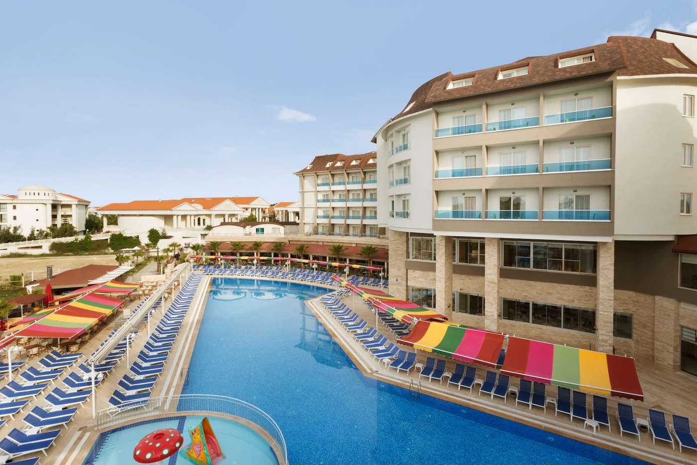 Full shot of the external area at the  Ramada Resort by Wyndham Side featuring the pool, sun loungers and rooms. 