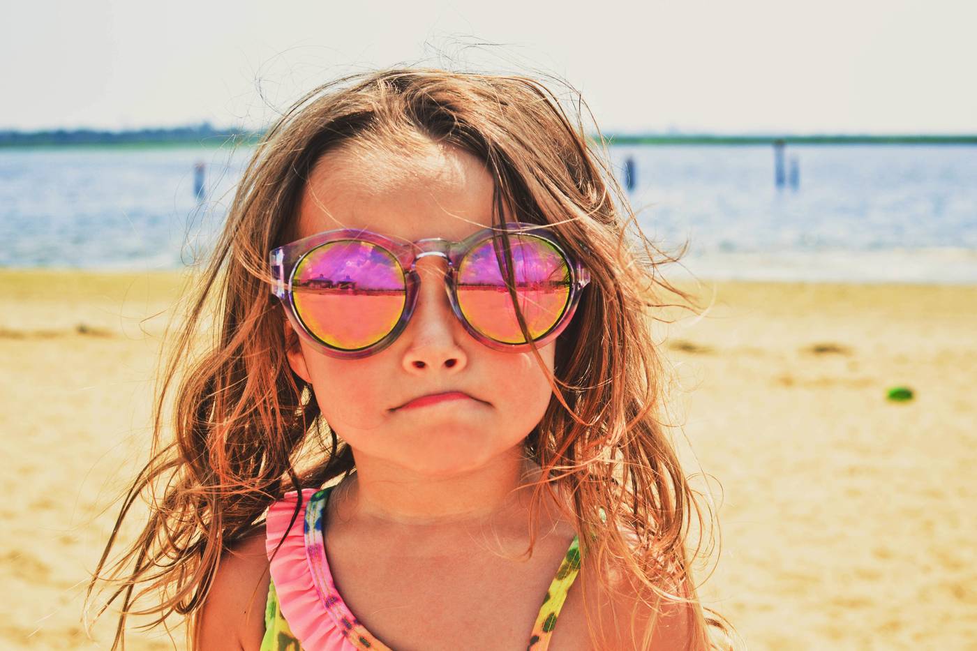 Little girl with sunglasses on the beach