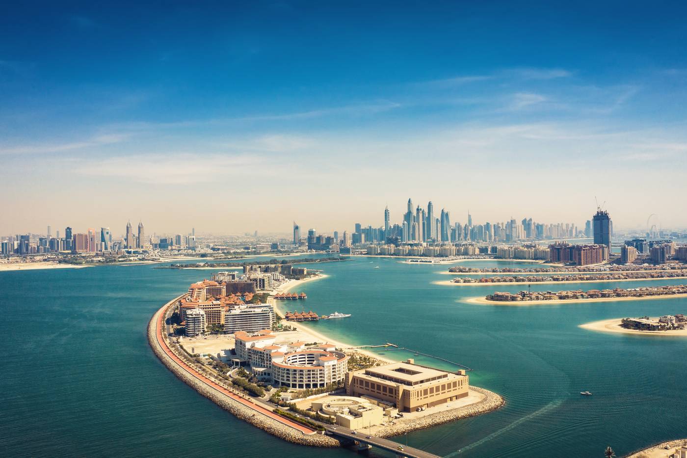Dubai cityscape with The Palm island in Jumeirah and blue sea.