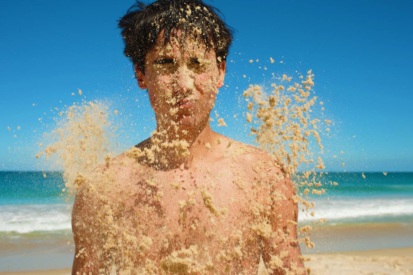 Boy with sand in his face