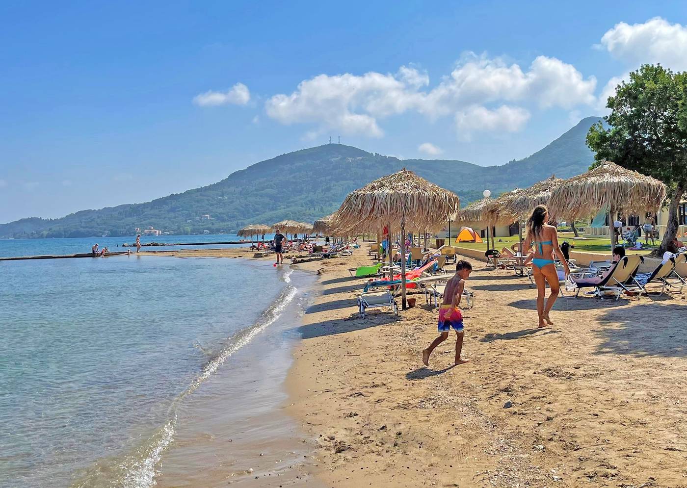 Beach with children playing, sun loungers and parasols