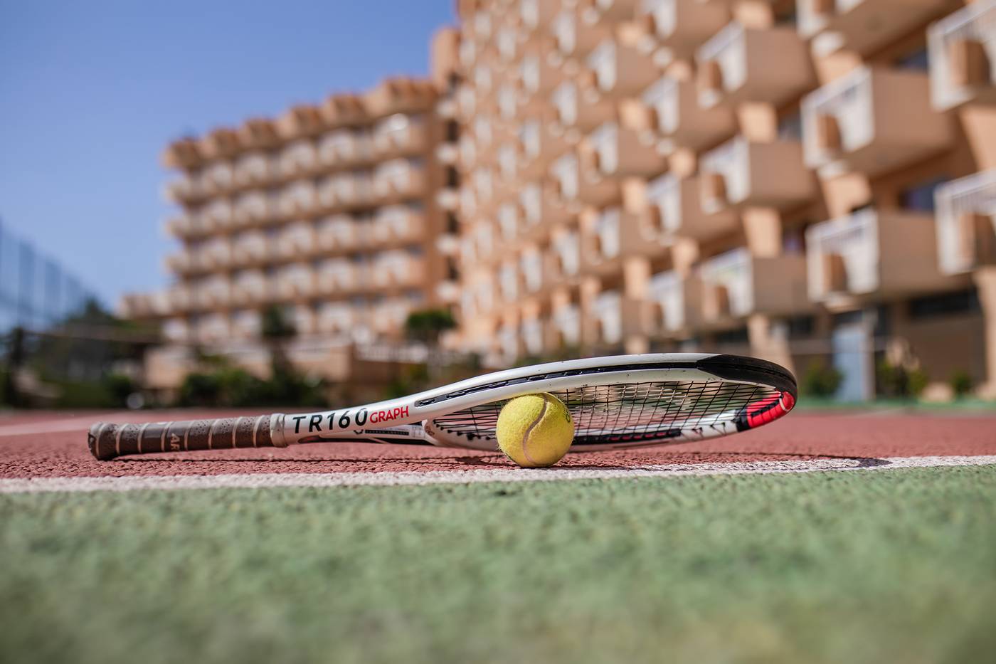 Close up of tennis racket and ball on the tennis court.