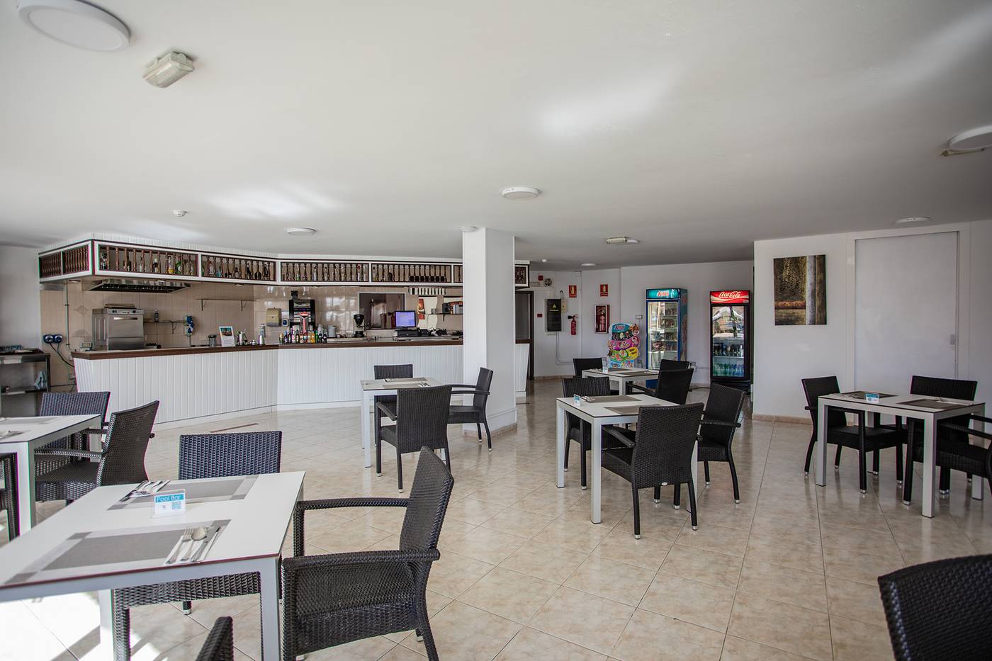 Bar area with vending machines, tables and chairs.