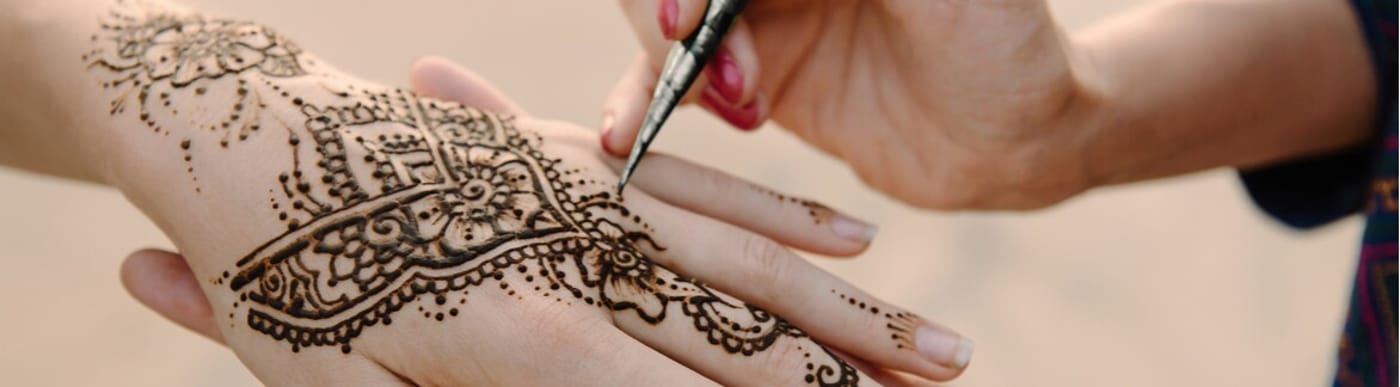 Henna being painted onto hand.